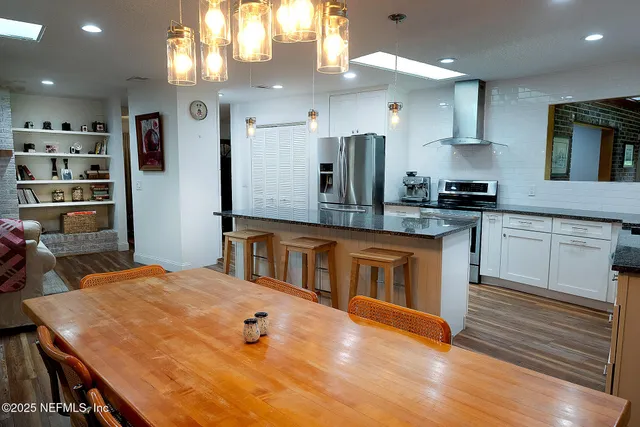 a kitchen with stainless steel appliances granite countertop a stove a sink and a refrigerator