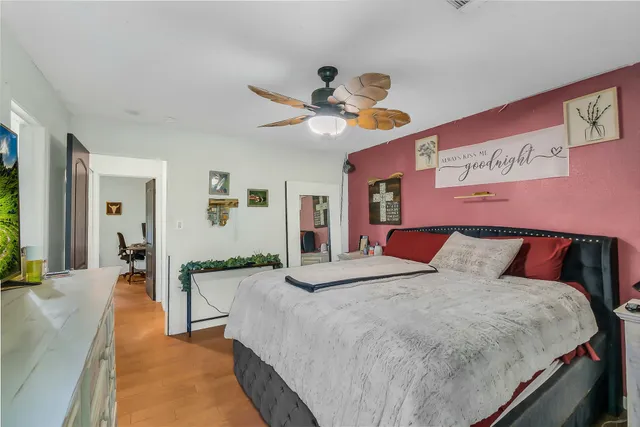 a bedroom with a large bed and a chandelier