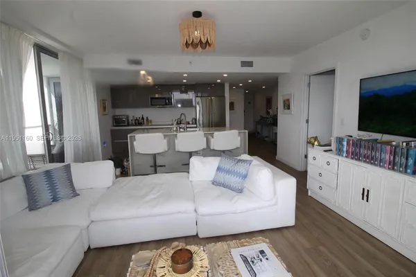 a kitchen with stainless steel appliances a dining table chairs and wooden floor
