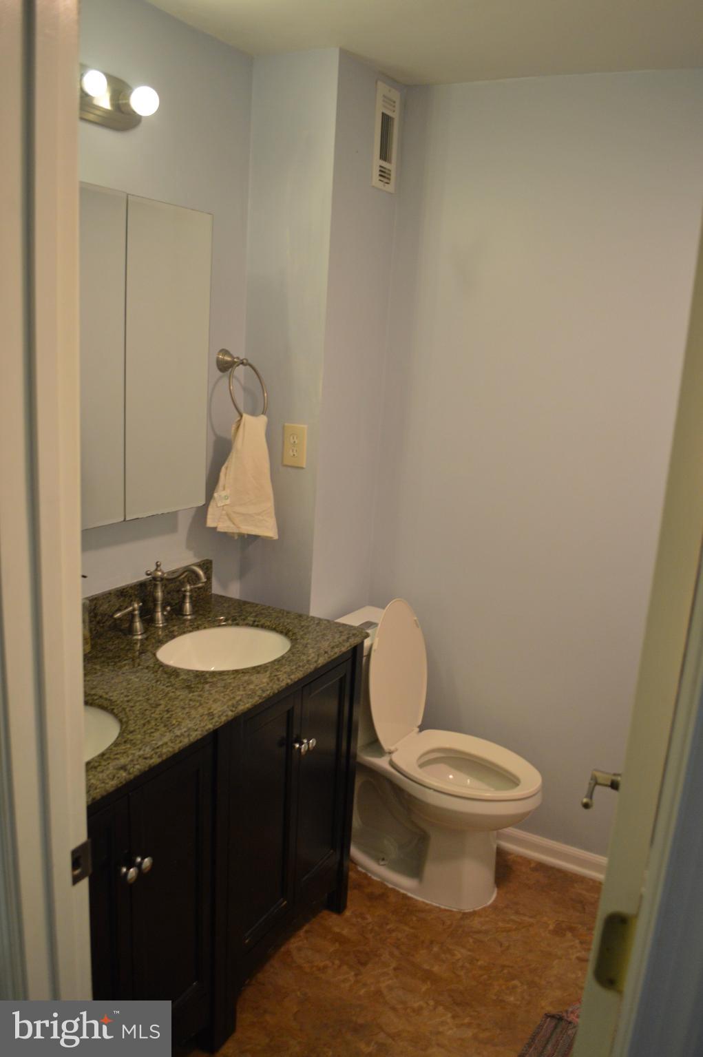 5953 Kedron Street Springfield, VA 22150 - Photo 19 of 28 a bathroom with a granite countertop sink a toilet and a mirror