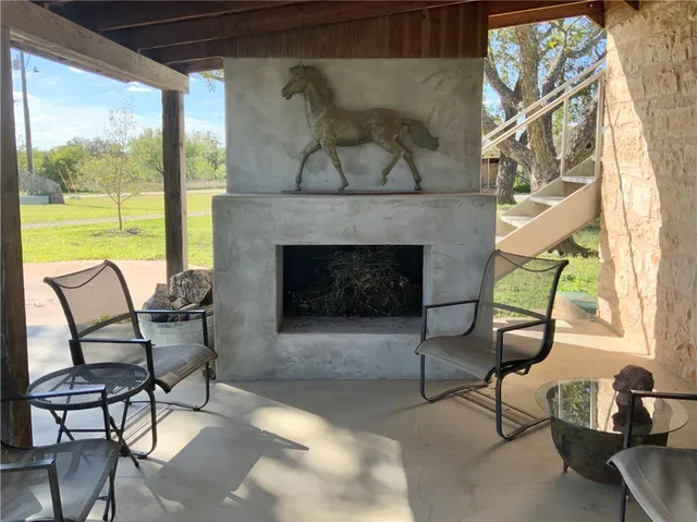 a living room with furniture a fireplace and a floor to ceiling window