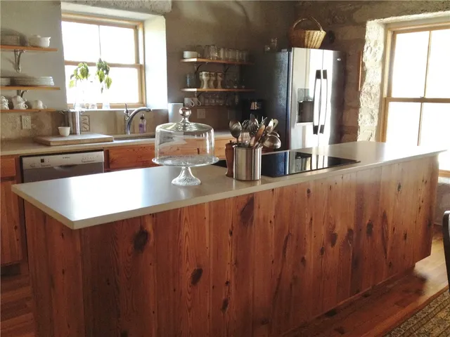 a kitchen with sink a window and chairs