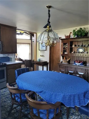 a bedroom with a bed a dresser and potted plant