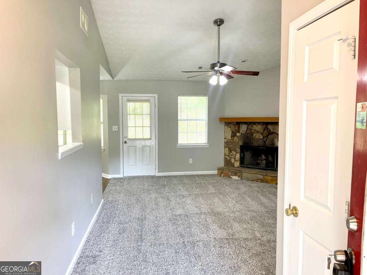 215 Mountain Ridge Covington, GA 30016 - Photo 3 of 23 a view of a livingroom with a fireplace a chandelier and couch