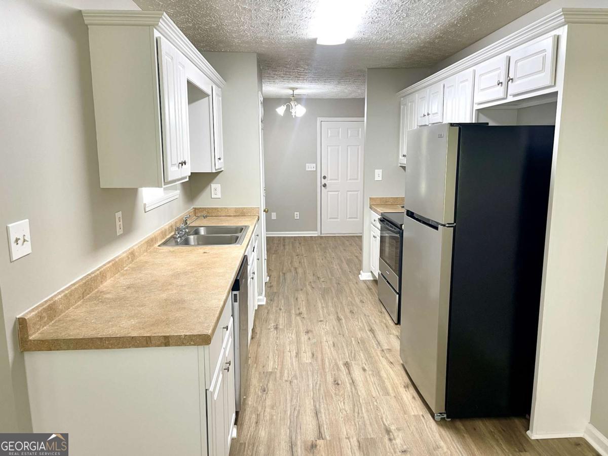 215 Mountain Ridge Covington, GA 30016 - Photo 7 of 23 a kitchen with a refrigerator a sink and cabinets