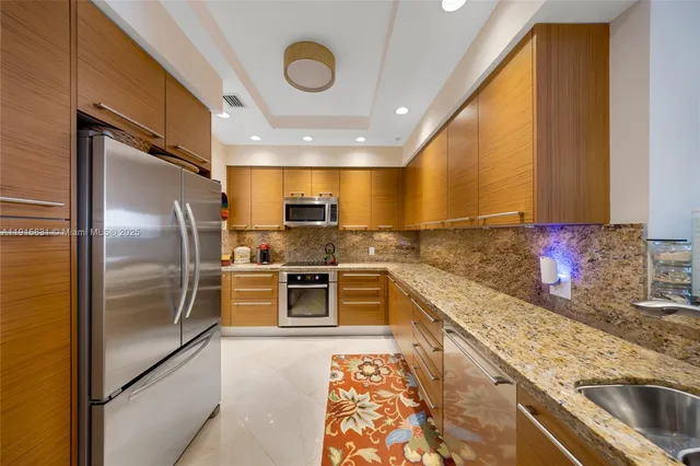 a kitchen with stainless steel appliances a refrigerator sink and microwave
