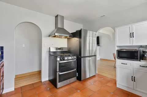 a kitchen with stainless steel appliances granite countertop a refrigerator and a stove top oven