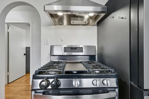 a stove top oven sitting inside of a kitchen