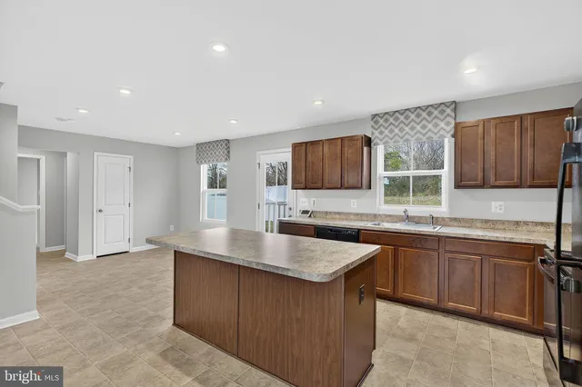 a kitchen with stainless steel appliances granite countertop a sink dishwasher stove top oven and refrigerator