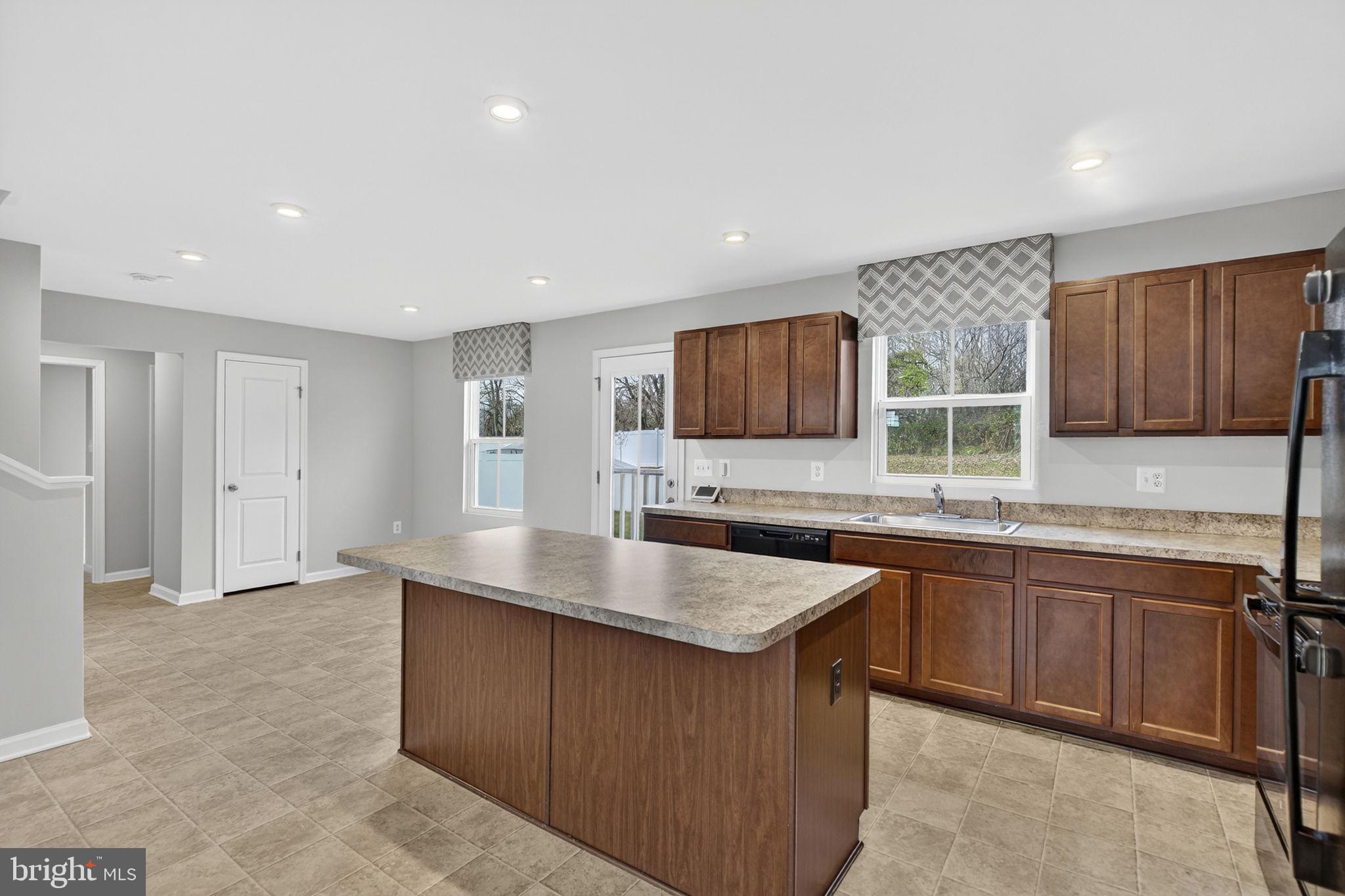 129 Birmingham Drive Middletown, VA 22645 - Photo 18 of 55 a kitchen with stainless steel appliances granite countertop a sink counter space cabinets and a large window