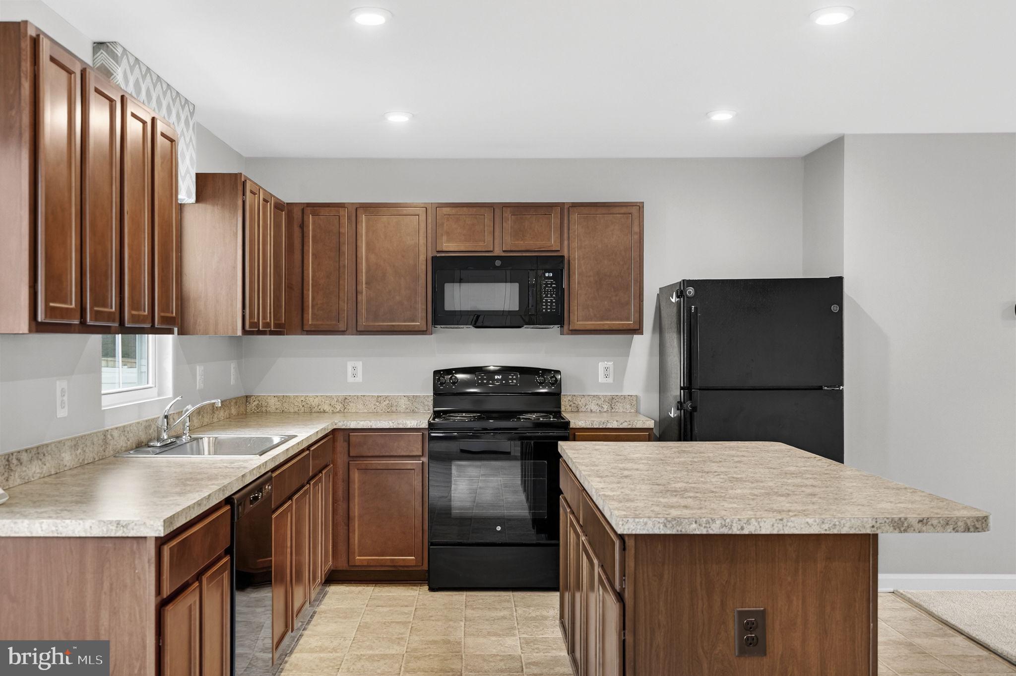 129 Birmingham Drive Middletown, VA 22645 - Photo 23 of 55 a kitchen with a sink dishwasher a stove and a refrigerator with wooden cabinet