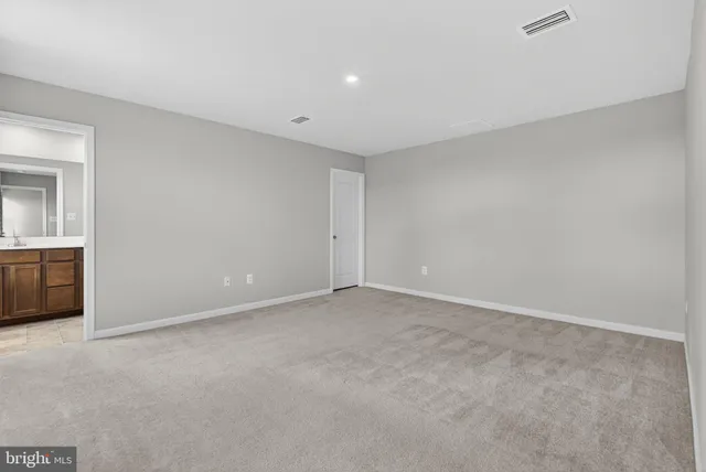 a bathroom with a granite countertop sink a toilet a mirror and a window