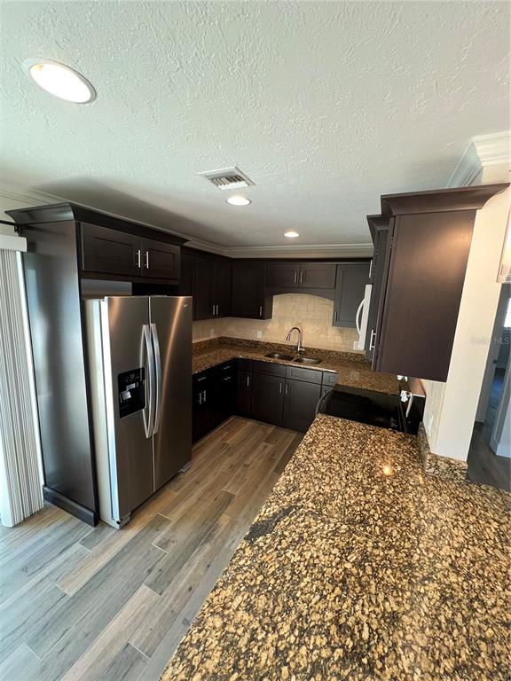511 West Retta Esplanade Punta Gorda, FL 33950 - Photo 8 of 19 a kitchen with stainless steel appliances wooden floor and a refrigerator