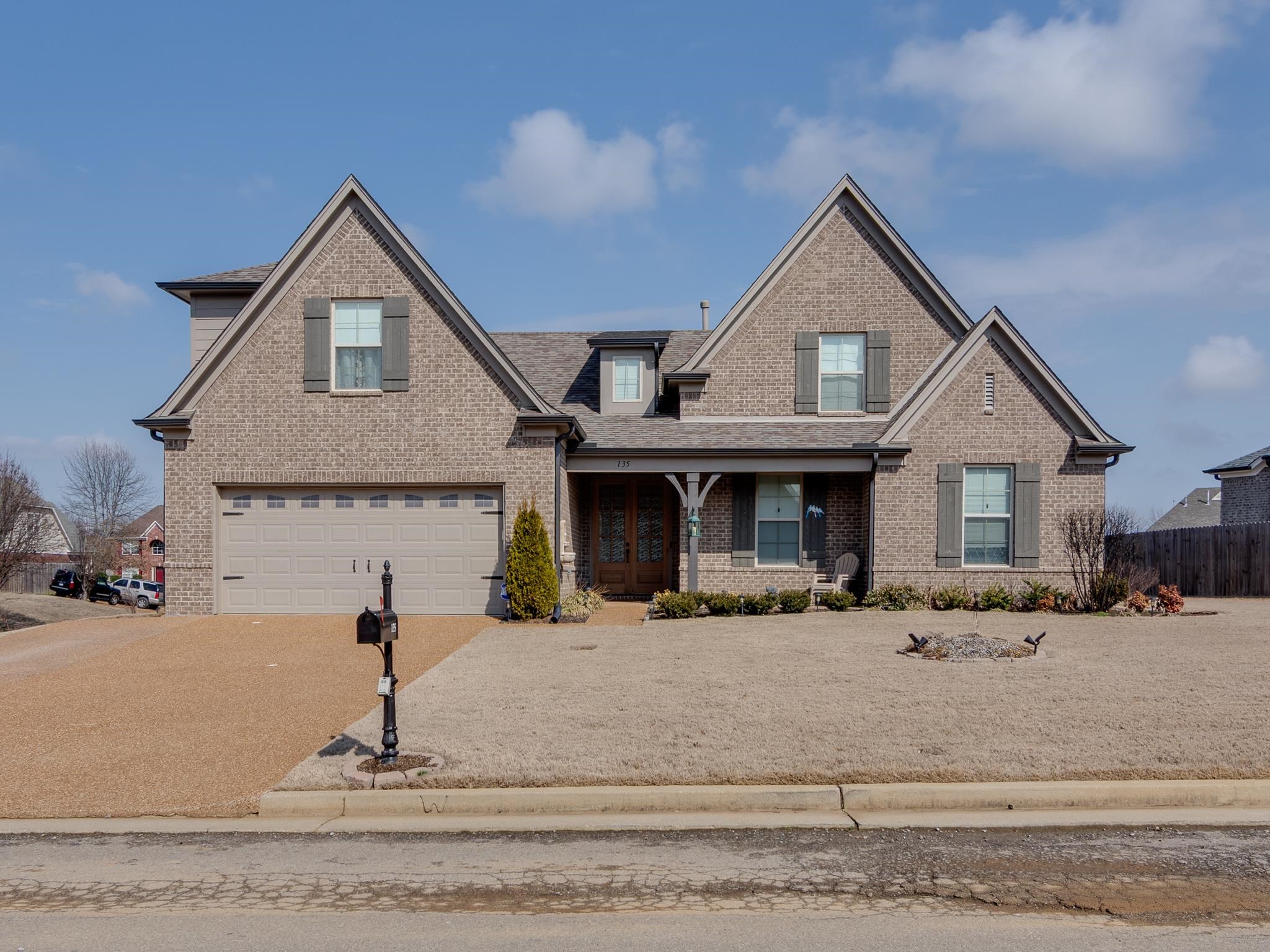 135 Chesnut Rdg Drive Oakland, TN 38060 - Photo 1 of 36 Craftsman-style home featuring brick siding, covered porch, driveway, a garage, and roof with shingles