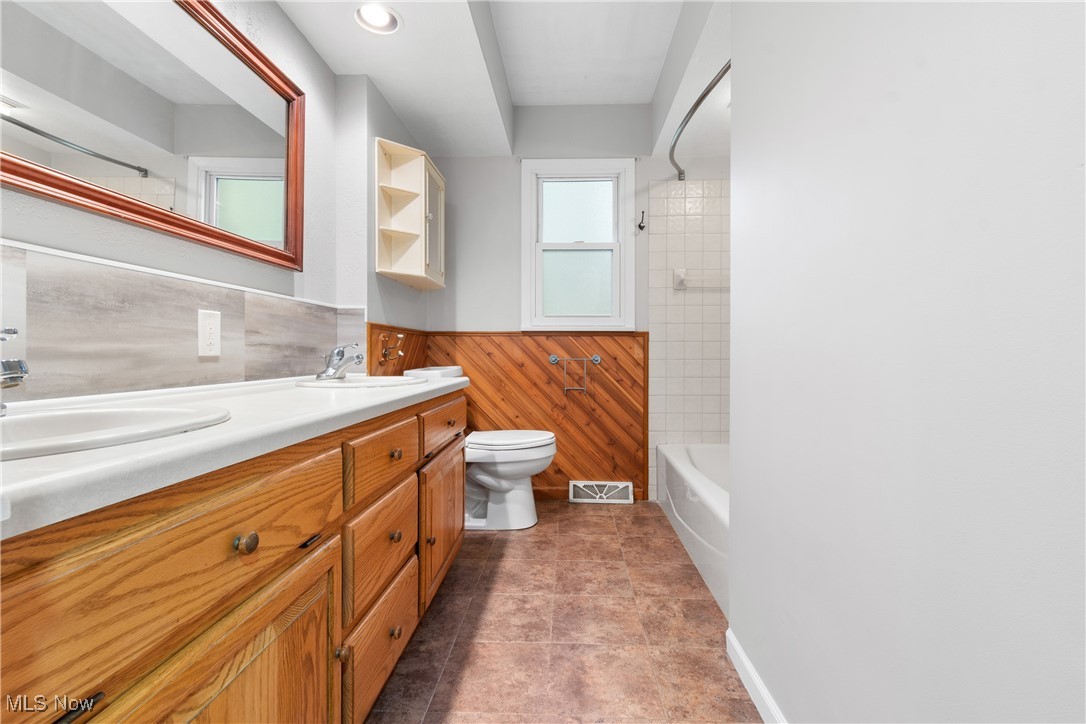 3143 Ethan Allen Road Barberton, OH 44203 - Photo 17 of 37 Bathroom featuring double vanity, a wainscoted wall, shower combination, and recessed lighting