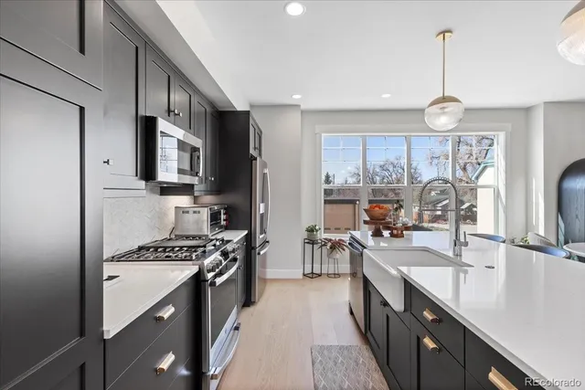 a kitchen with kitchen island granite countertop a sink appliances cabinets and a counter top space