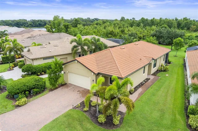 an aerial view of a house with a yard and lake view