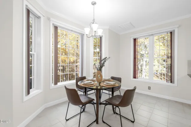 an empty room with wooden floor chandelier and windows