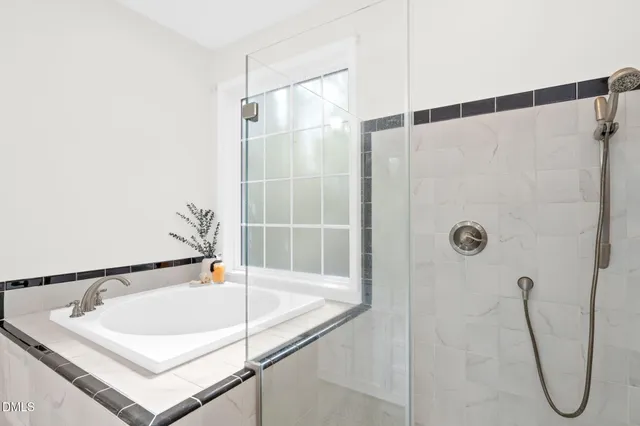 a view of an empty room with chandelier fan and wooden floor