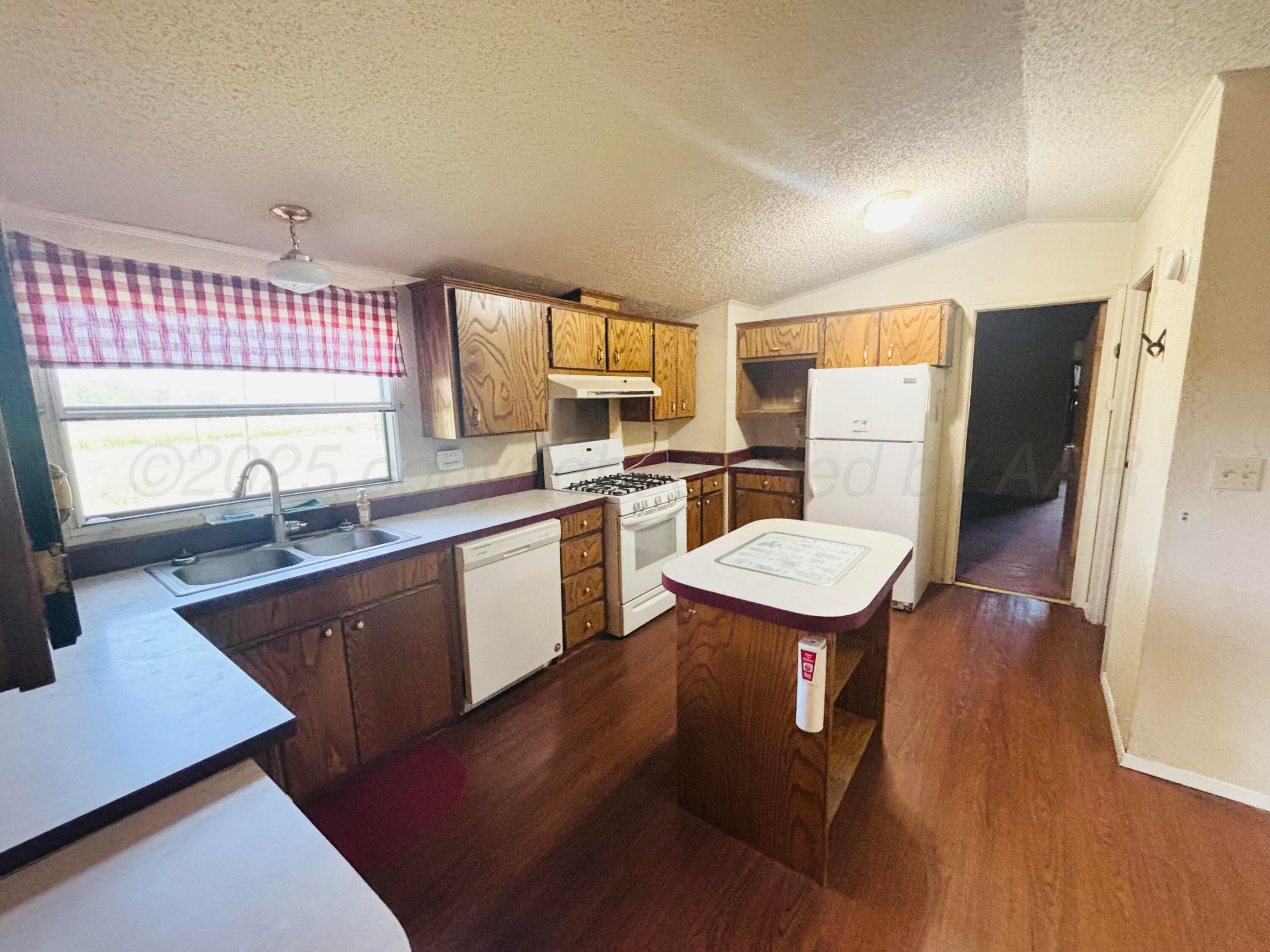 310 County Road KC Childress, TX 79201 - Photo 17 of 25 a kitchen with a sink a refrigerator and a stove