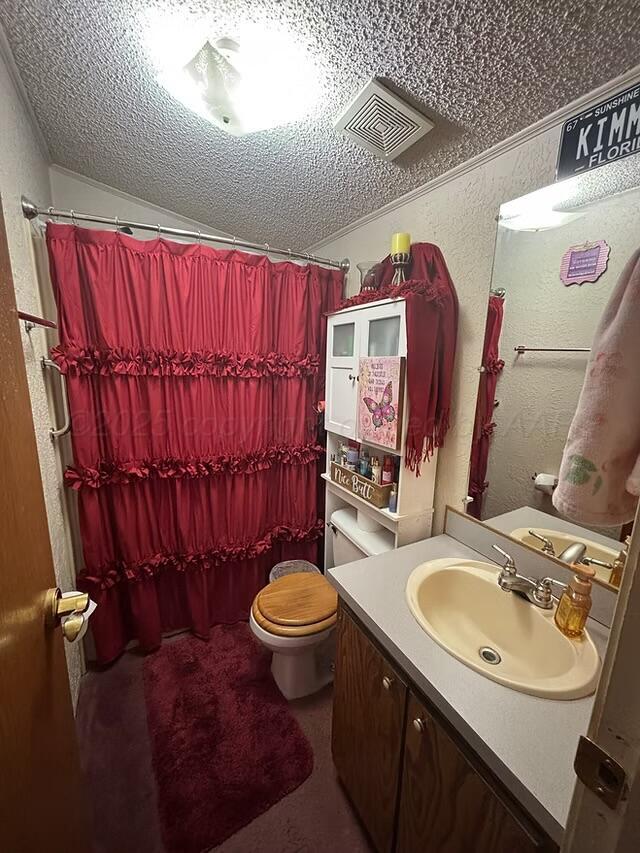 310 County Road KC Childress, TX 79201 - Photo 23 of 25 a bathroom with a sink vanity mirror and toilet
