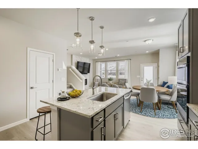 a kitchen with a dining table chairs and white cabinets