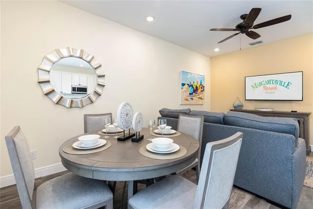 a view of a dining room with furniture and a chandelier fan