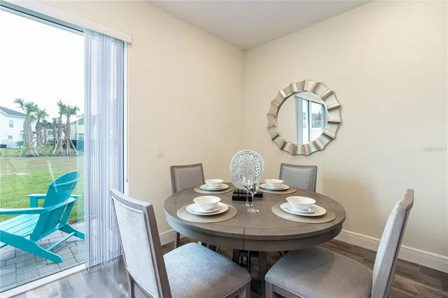 a view of a dining room with furniture a rug and wooden floor
