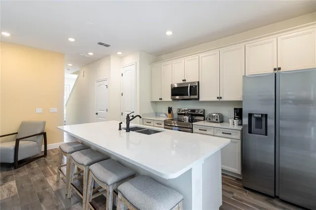 a kitchen with a sink a counter space appliances and cabinets