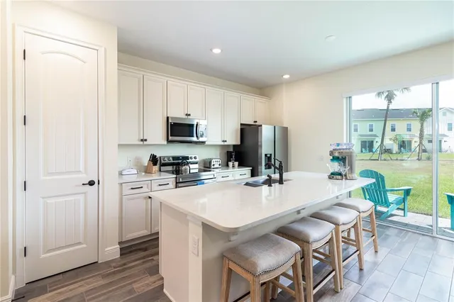a kitchen with a table chairs refrigerator and a window