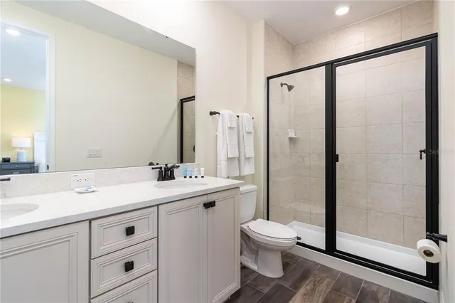 a bathroom with a double vanity sink toilet and shower
