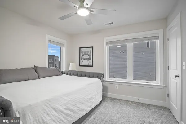 a spacious bedroom with a bed a large mirror and a window