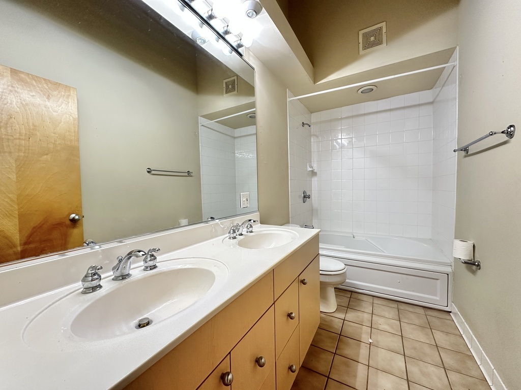 933 West Irving Park Road, Unit C Chicago, IL 60613 - Photo 12 of 20 a bathroom with a sink a toilet and shower