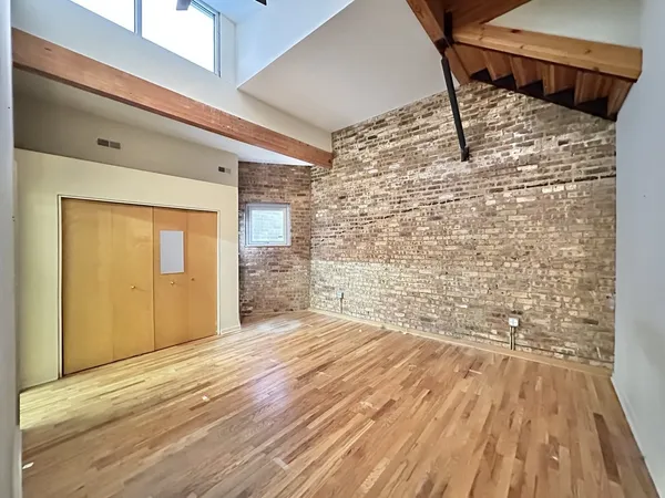 a view of empty room with wooden floor