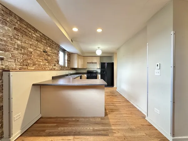 a view of kitchen with stainless steel appliances granite countertop refrigerator sink and cabinets