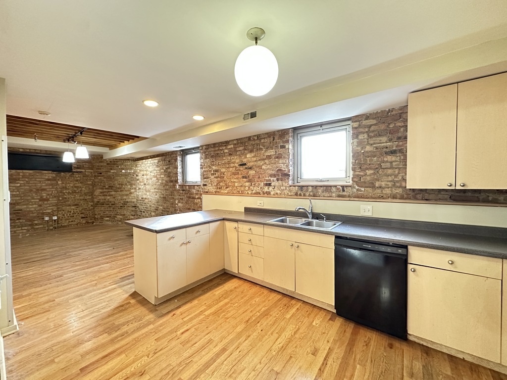 933 West Irving Park Road, Unit C Chicago, IL 60613 - Photo 3 of 20 a kitchen with granite countertop a sink cabinets and wooden floor