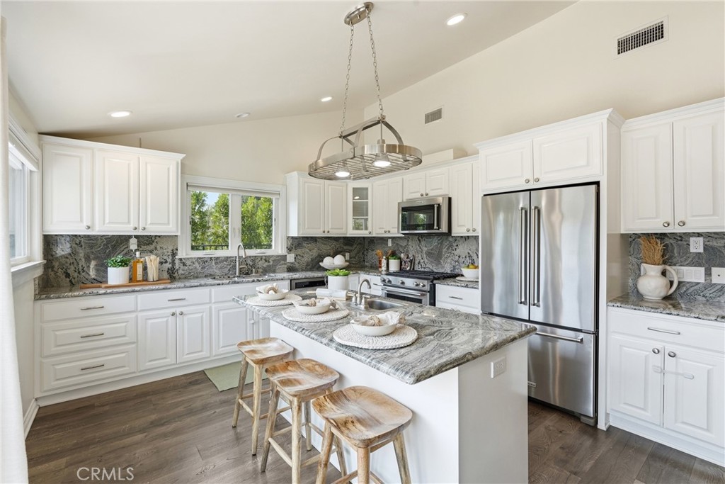 3240 Brace Canyon Road Burbank, CA 91504 - Photo 11 of 39 a kitchen with white cabinets stainless steel appliances and dining table