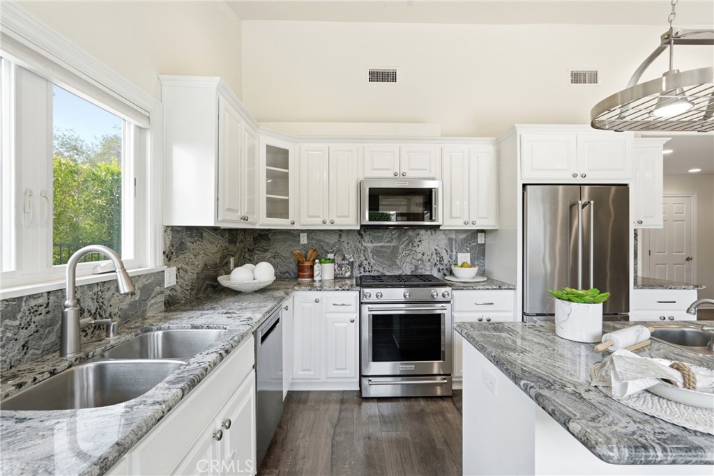 3240 Brace Canyon Road Burbank, CA 91504 - Photo 12 of 39 a kitchen with stainless steel appliances granite countertop a sink a stove and a microwave