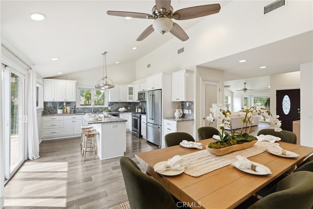 3240 Brace Canyon Road Burbank, CA 91504 - Photo 9 of 39 a open dining room with stainless steel appliances kitchen island granite countertop a table chairs and a refrigerator