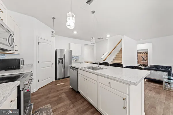 a kitchen with white cabinets and stainless steel appliances