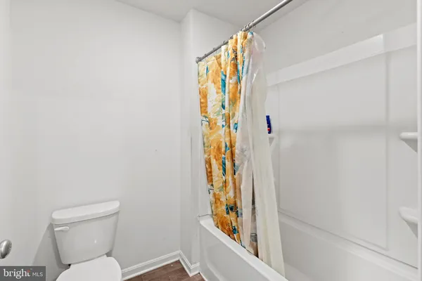 a bathroom with a toilet and a shower curtain