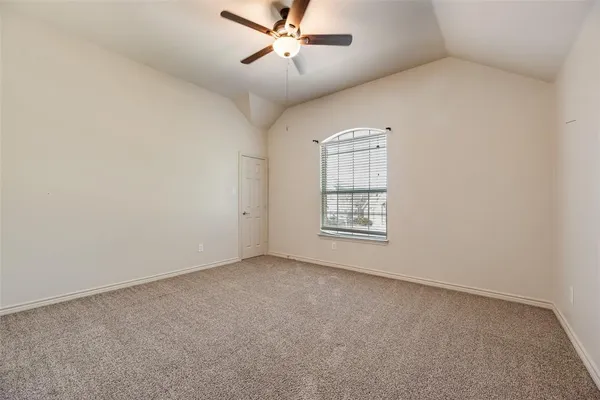 an empty room with windows and fan