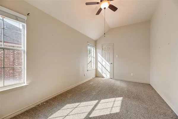 a view of empty room with a window and chandelier fan