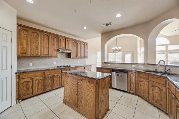 a kitchen with granite countertop a sink stove and cabinets