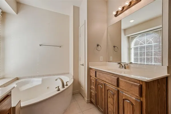 a bathroom with a tub sink and mirror