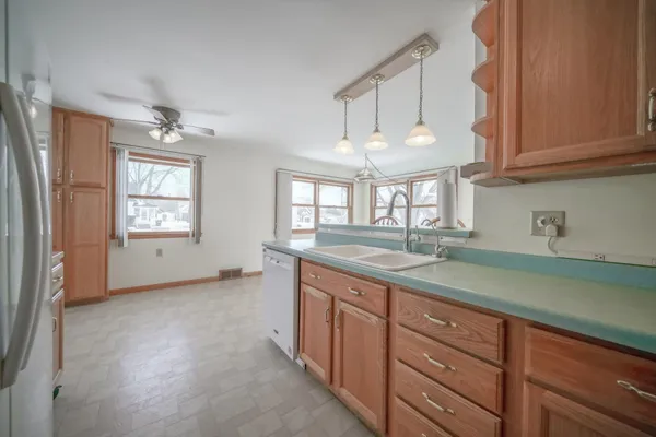 a kitchen with granite countertop a sink a window and cabinets
