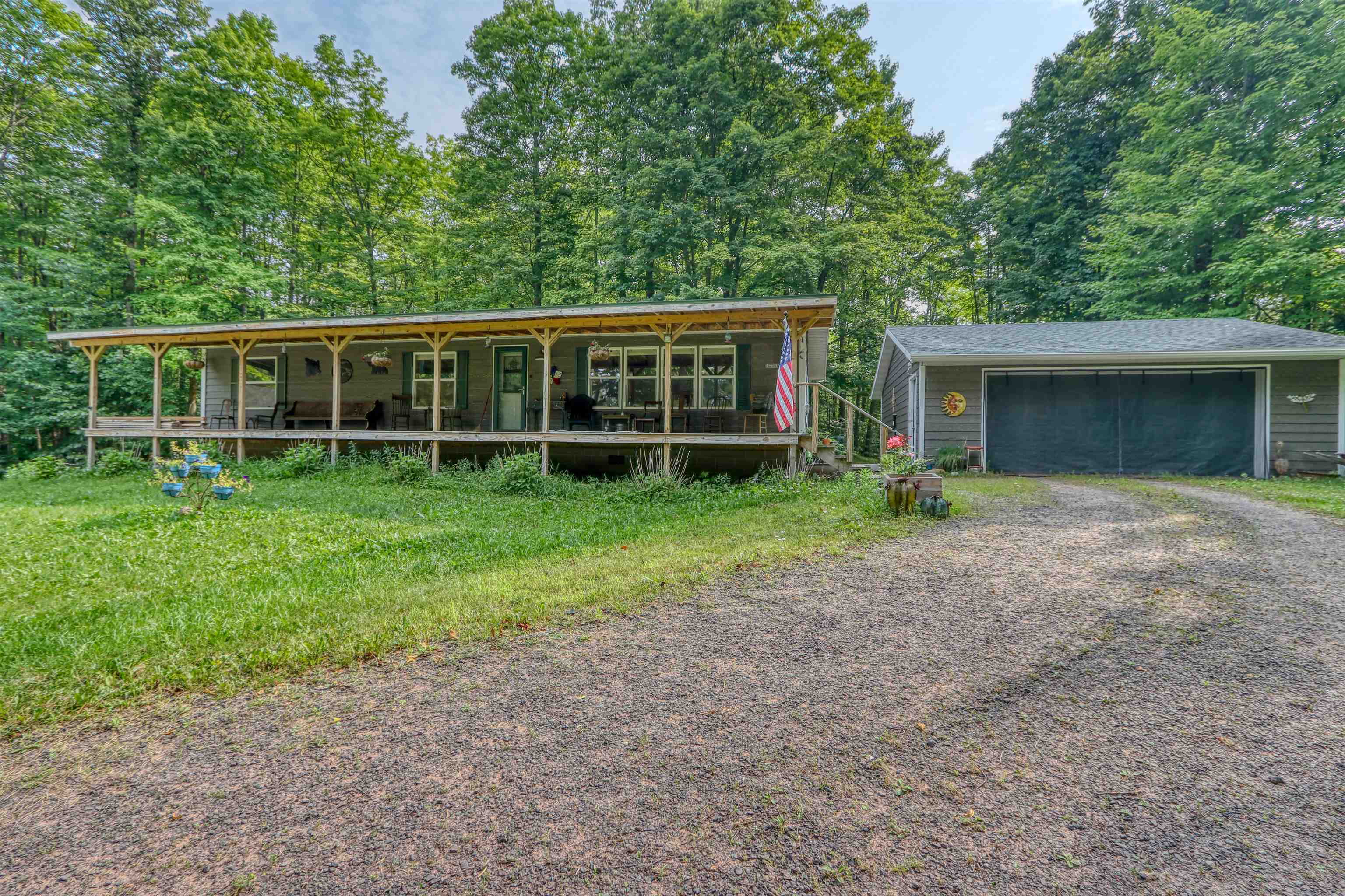 View of front of home featuring a porch and an outbuilding