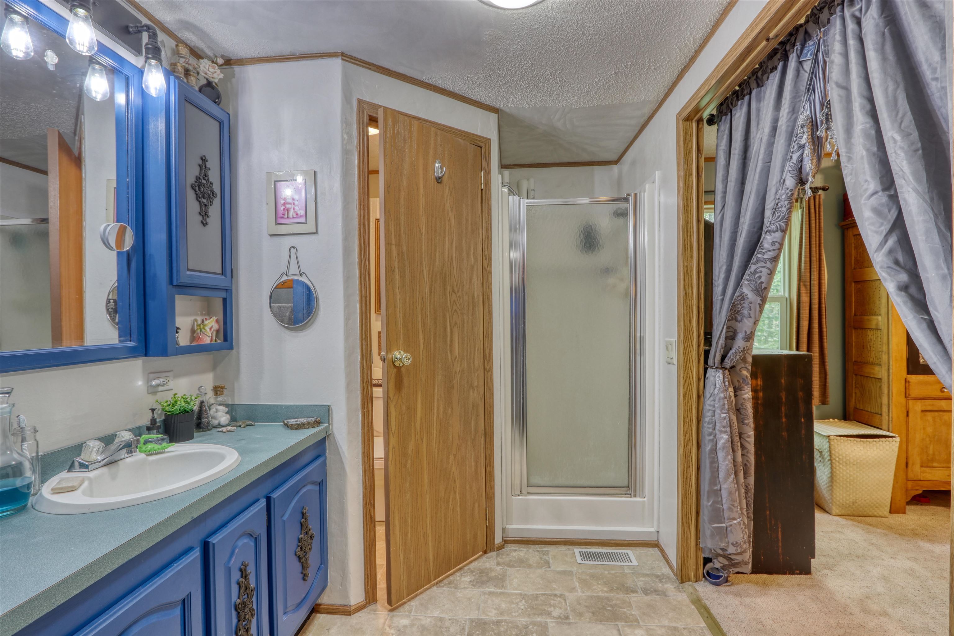 48400 Old Grade Road Cable, WI 54821 - Photo 30 of 58 Full bathroom featuring a textured ceiling, a stall shower, vanity, and ornamental molding