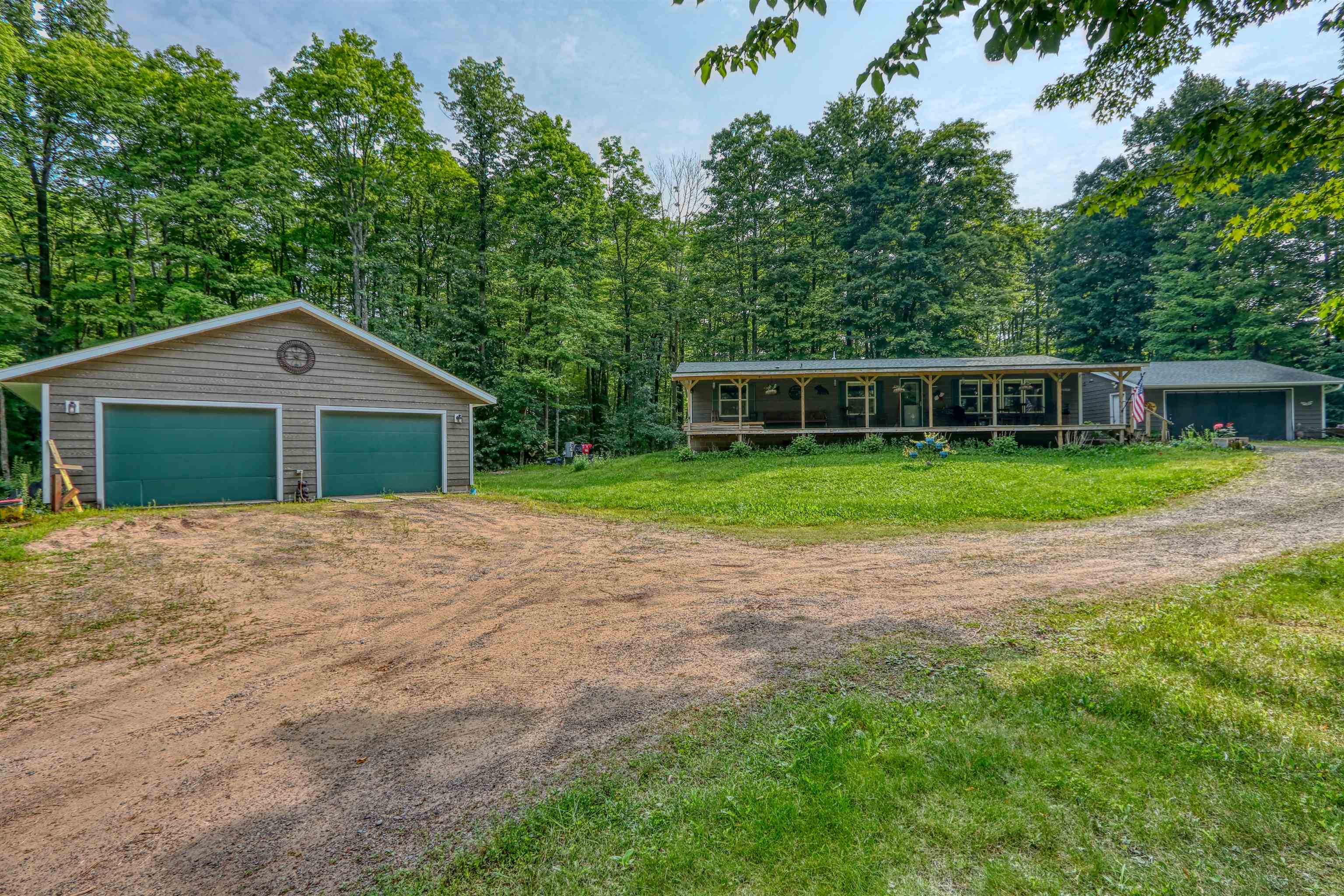 48400 Old Grade Road Cable, WI 54821 - Photo 6 of 58 View of front facade with an outbuilding, a detached garage, driveway, and a front yard