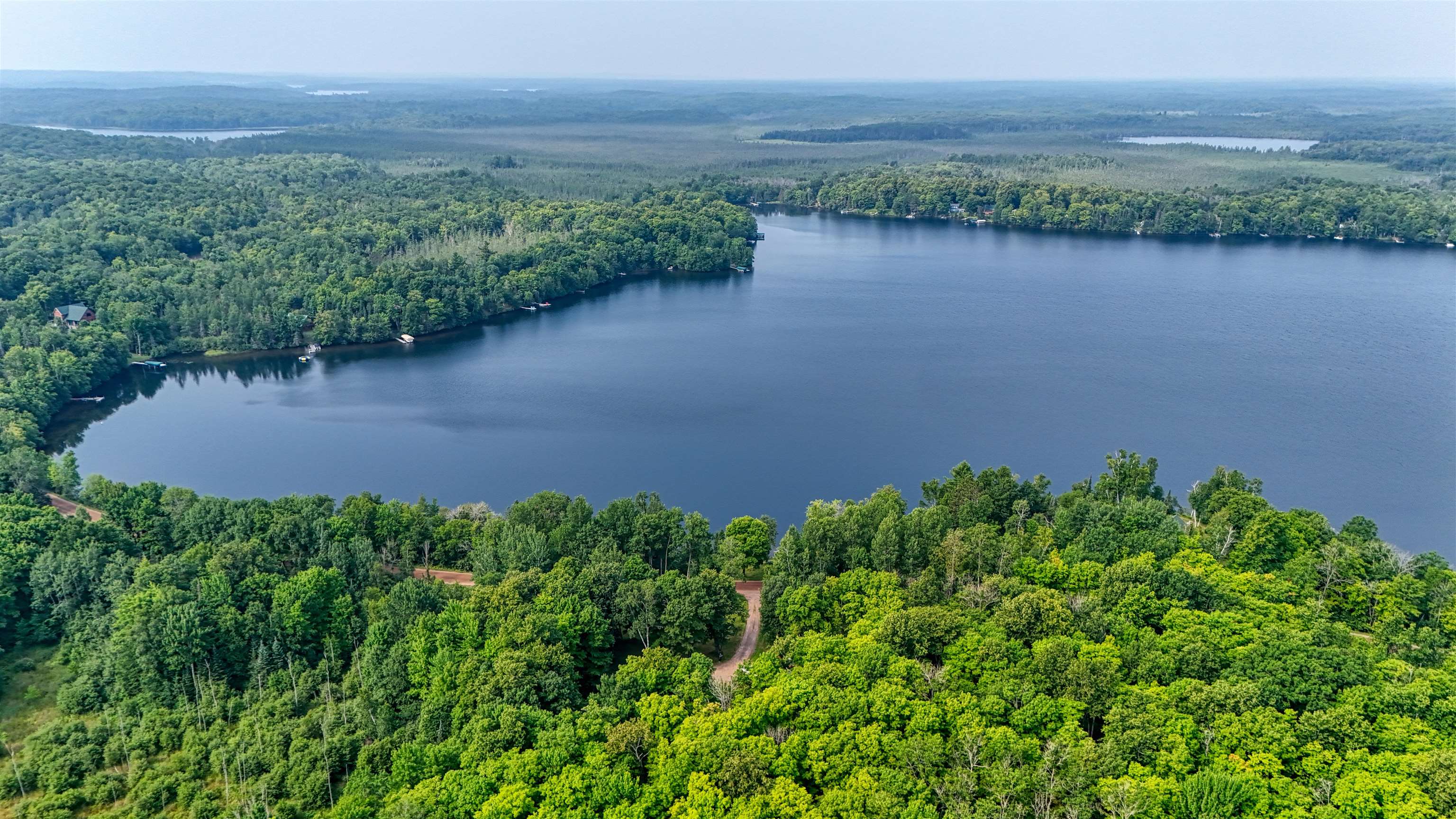 48400 Old Grade Road Cable, WI 54821 - Photo 6 of 58 Bird's eye view of a heavily wooded area and a nearby body of water